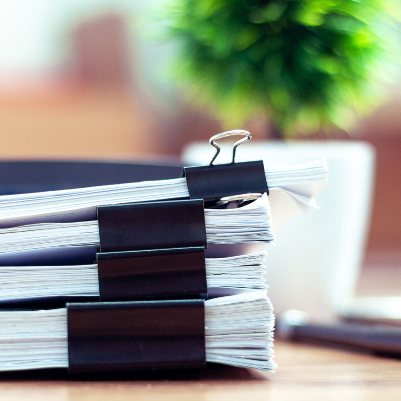 Stack of documents placed on a business desk in a business office.